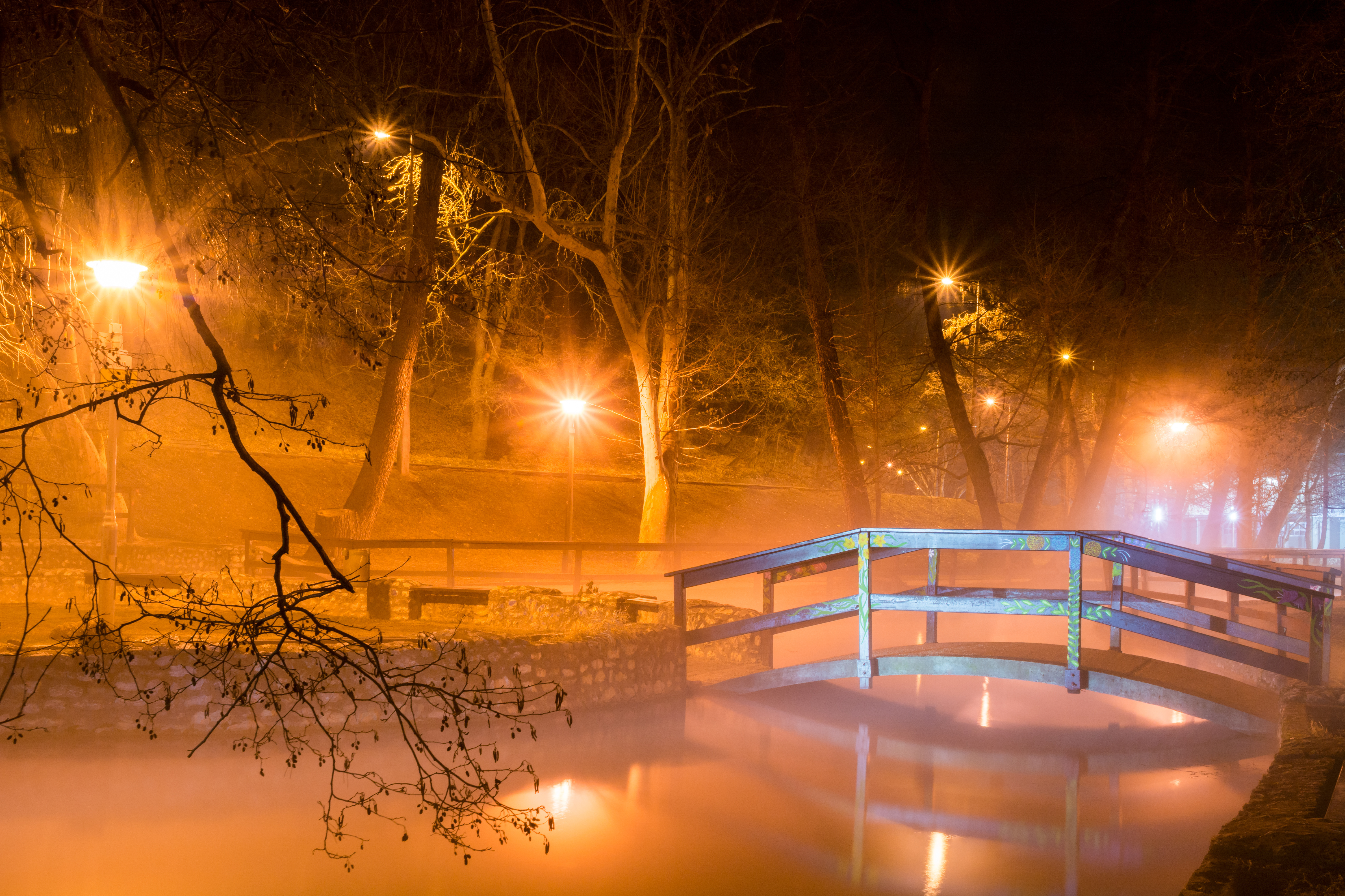 Piękna nocna scena z drewnianym mostem, oświetlonym przez latarnie w Miskolctapolca, Węgry